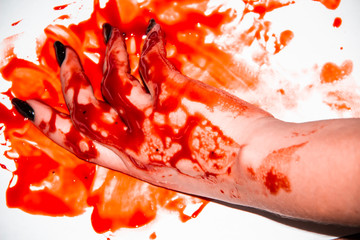 A Female hand in the blood. A Black manicure and the blood around.Terrible and bloody background.