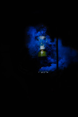 hombre con mascara de gas y bote de humo azul en fondo negro