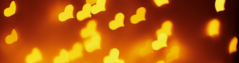 Abstract background with a golden blurred lights in heart shape. Valentine day concept