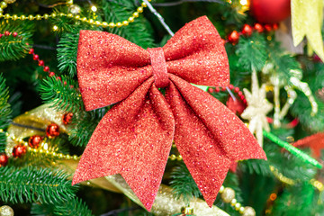 Red bow on the Christmas tree. Holiday decorations. Close-up.