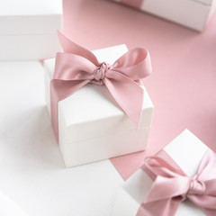 Gift boxes wiyh powdery ribbon. Powdery background. Silver bracelet with charms. Gift box for the New Year and Christmas. Best gift for Valentines Day and Mothers day.