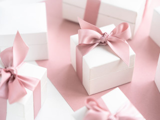 Gift boxes wiyh powdery ribbon. Powdery background. Silver bracelet with charms. Gift box for the...