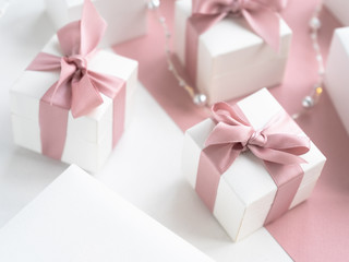 Obraz premium Gift boxes wiyh powdery ribbon. Powdery background. Silver bracelet with charms. Gift box for the New Year and Christmas. Best gift for Valentines Day and Mothers day.