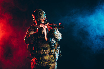 militant soldier man in action, wearing green uniform with special equipment, shooting, pointing...