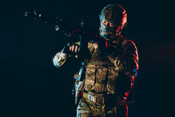 soldier man serving in military forces hold weapon in hands in space with ultra violet rays