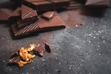 Orange zest pieces of dark chocolate on a dark background
