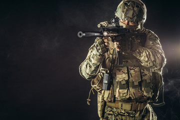 military forces concept., young brave soldier holding weapon looking for danger to protect...