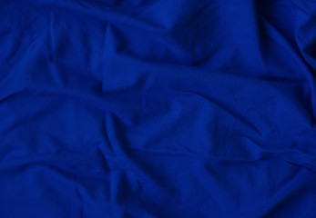 Crumpled blue fabric texture close up. Trendy tone of 2020 classic blue color