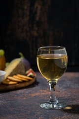 glass of white wine and snacks, vertical