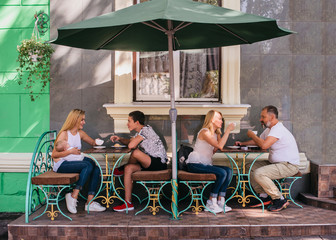 holidays and relations concept - happy family at cafe or restaurant terrace