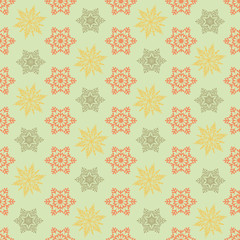 Seamless pattern. Multi-colored Snowflakes on a green background.