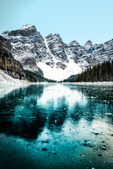 Moraine lake panorama in winter with frozen water and snow covered mountains, Banff National Park,...