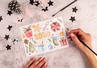 Woman hands painting a christmas pictures flat lay top view