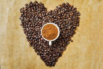 Coffee beans in love shaped shrouding a coffee cup
