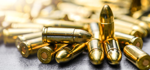 Bullets ammunition on stone table wide banner or panorama. Bullet pile background copy space.  Magazines, rounds and ammo military technology. - obrazy, fototapety, plakaty