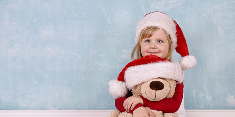 lachendes Mädchen kuschelt mit Teddybär