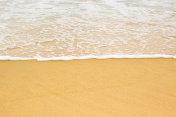 white sea foam on yellow sand, sea background, sandy beach