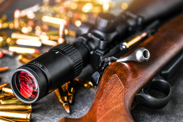 Close up of rifle scope hunting on wooden ammonition background. Hunt sniper gun, optics scopes...