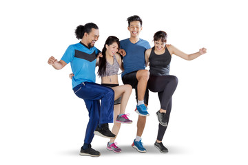 Four people lifting their right leg together