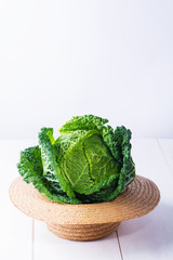fresh organic cabbage headsin a straw hat. Antioxidant balanced diet eating, creative food, peganism