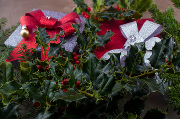 Gift with ribbon as background on ilex and coniferous branch. Symbol of Christmas, gifts and...