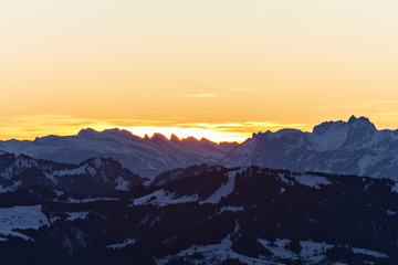 Obraz premium Colorful sunset at the Churfirsten mountains (Appenzell Alps, Switzerland). Alpine landscape with rocky mountains in winter. Copy space
