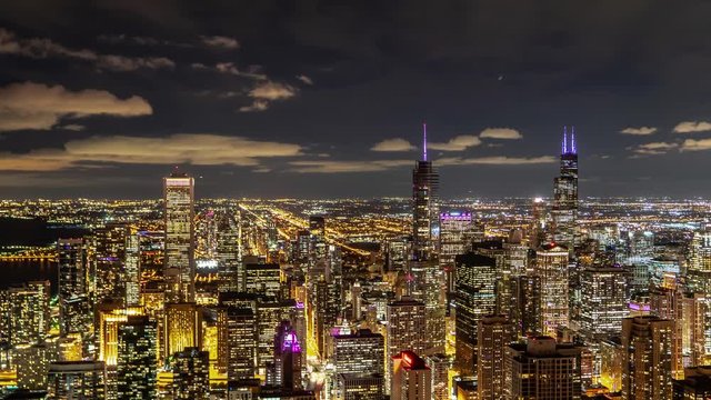 An incredible aerial nighttime zoom in time lapse of downtown Chicago highrise buildings with lights looking south on Michigan Avenue, the magnificent mile as traffic moves below.