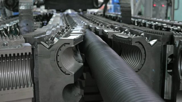 Manufacture of plastic water pipes. Manufacturing of tubes to the factory. The process of making plastic pipes on the machine tool with the use of water and air pressure. Special corrugated forms of