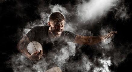 Handsome rugby player in action - obrazy, fototapety, plakaty