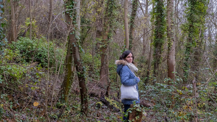 Naklejka premium Girl walking in a forest at fall 