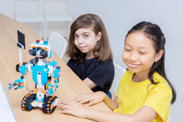 Two children nervously presenting their blocks robot