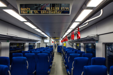 empty interior of an electric train car with blue passenger seats in perspective in Moscow Russia