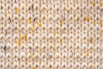 Texture of Wool Knit Beige Fabric Interspersed with Yellow Yarn. Sweater Background Close-Up View