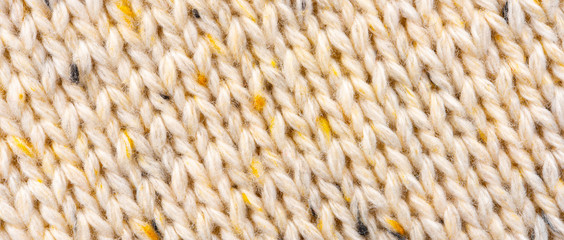 Texture of Wool Knit Beige Fabric Interspersed with Yellow Yarn. Sweater Background Close-Up View
