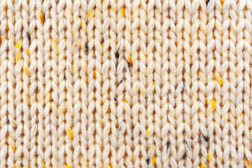 Texture of Wool Knit Beige Fabric Interspersed with Yellow Yarn. Sweater Background Close-Up View