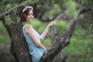 Girl in blue dress in green park
