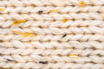 Texture of Wool Knit Beige Fabric Interspersed with Yellow Yarn. Sweater Background Close-Up View