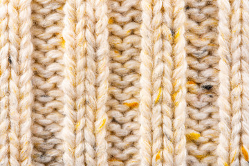 Texture of Wool Knit Beige Fabric Interspersed with Yellow Yarn. Sweater Background Close-Up View