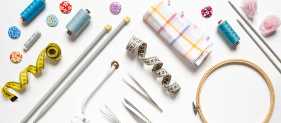 Sewing flat lay top view Composition with threads and sewing accessories on wnite background, flat lay banner