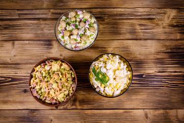 Fototapeta na wymiar Set of festive mayonnaise salads on wooden table. Top view