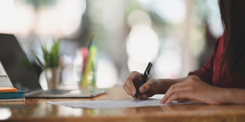 Fototapeta premium Close-up young businesswoman sign or writing paper.