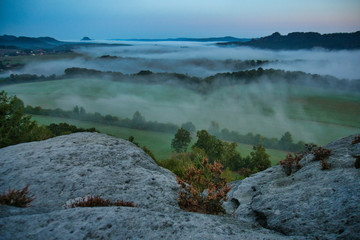 Fototapeta premium Faszinierende, beeindruckende Morgenstimmung mit Nebel über den Elbe, Täler im Nationalpark Sächsische Schweiz. Blick von der Kaiserkrone auf Zirkelstein, Rosenberg, Schrammsteine bis Lilienstein.