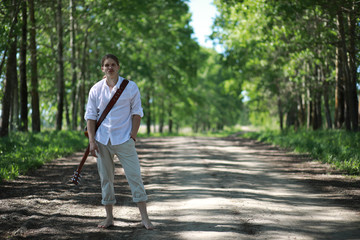 A man with a guitar on summer day outdoors