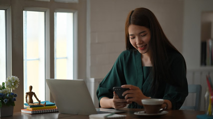 Asian woman using her mobile phone and enjoy moment.