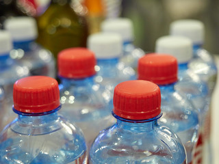 plastic bottles with drinking water. colored covers. close up