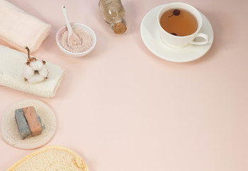 Creative flat lay of bath accessories beauty spa concept with copy space handmade soap rose and clay mask top view cup of tea