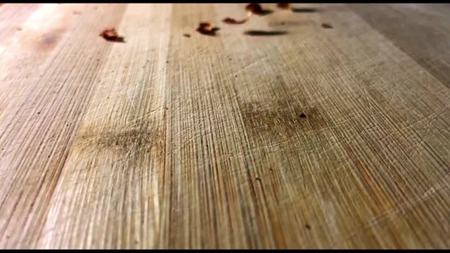 Close up slow motion peanuts in cover fall down on wooden desk 