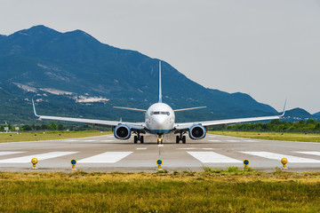 Fototapeta na wymiar Sunny view of airplane taking off from airport of Tivat, Montenegro.