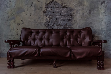 Luxurious leather, brown sofa, grey wall. classic vintage furniture.