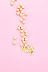 Beauty products blusher balls pearls on pink background. Vertical. Flat lay